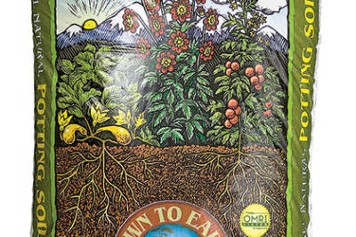 Large bag of Down to Earth All Natural Potting Soil with drawing of plants growing out of soil with rising sun and mountain in background